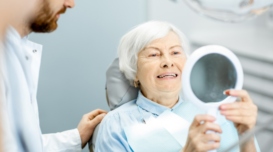 elderly lady at dentist looking into a mirror