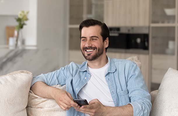 composite bonding man smiling on sofa