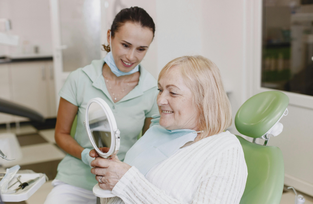 Denplan elderly lady at dentist holding a mirror